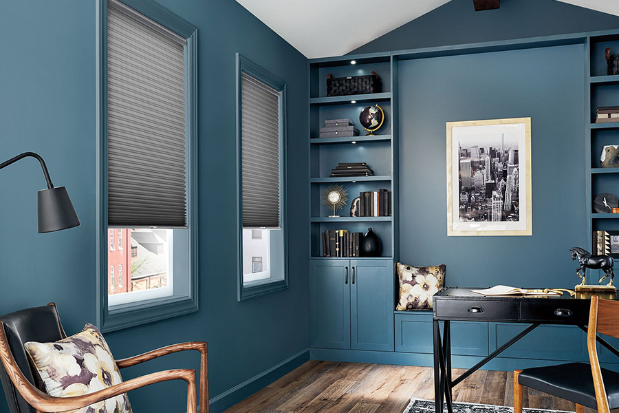 Gray cellular shades on windows in a blue home office