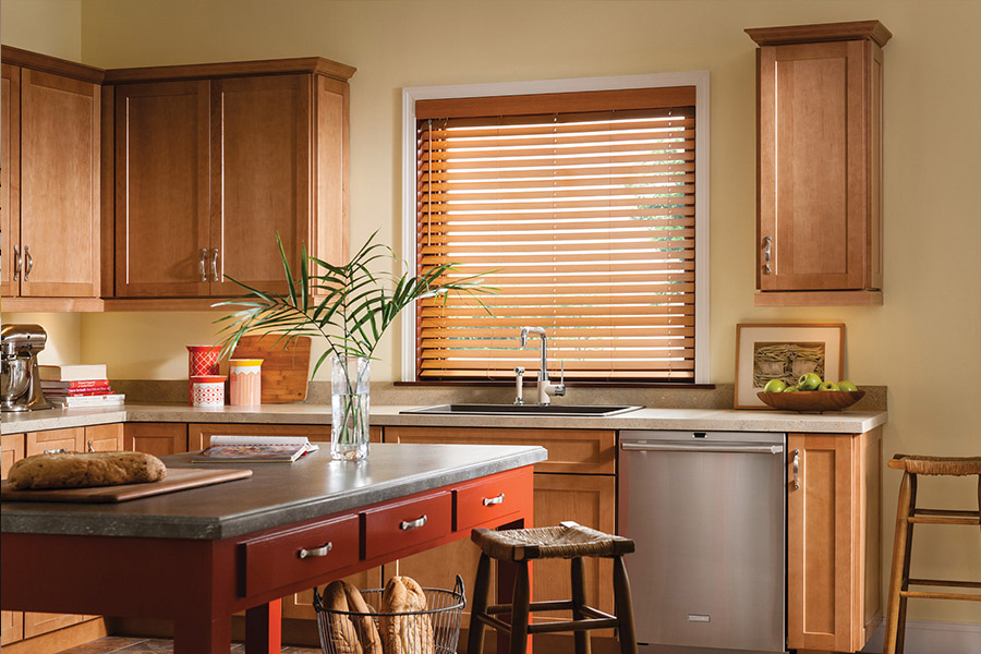 Dark faux wood blinds above a kitchen sink